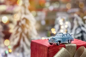Small car placed on a present symbolizing innovation and the future of smart driving.
