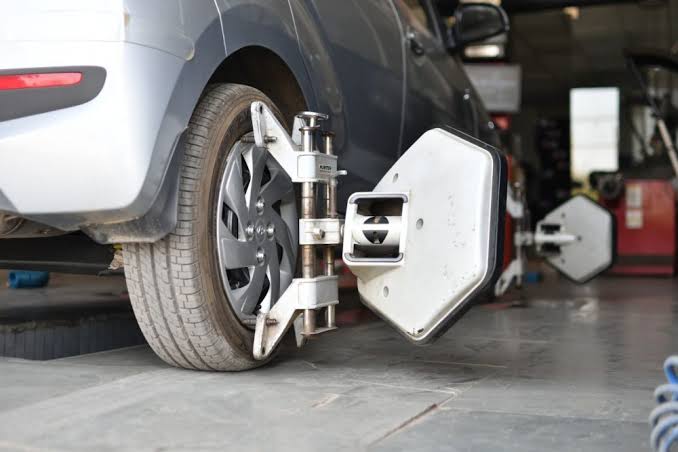 Computerized wheel alignment equipment attached to a car wheel during a wheel alignment service