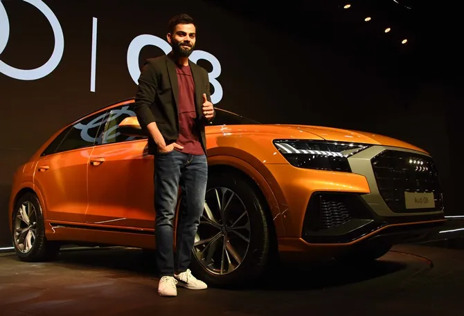 Virat Kohli posing with the Audi Q8 luxury SUV at its launch event.