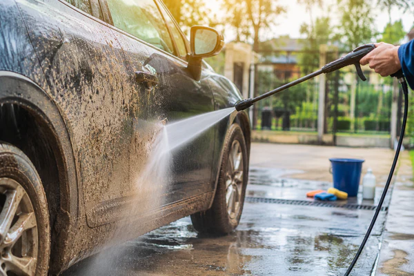 Car being washed and dried after driving in the rain to prevent rust and maintain the vehicle's paint finish.