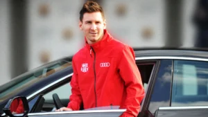 Lionel Messi standing beside an Audi car during his Barcelona years