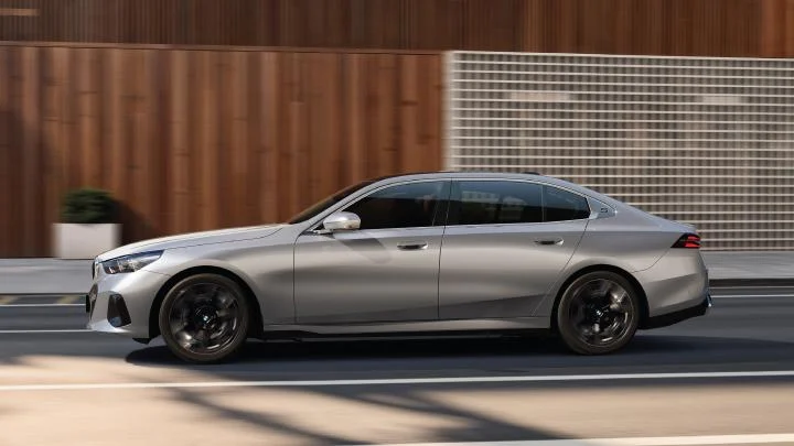 BMW i5 LWB electric sedan shown in side profile on a city road
