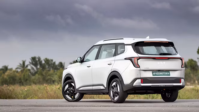 Kia Carens Clavis EV viewed from the rear three-quarter angle on a road